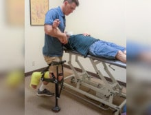 Jeff wearing an iWALK while performing physical therapy on a patient - iWALKFree