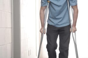 Young man walking with crutches