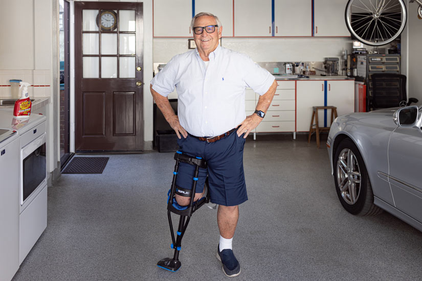Man standing in his garage with an iWALK hands-free crutch, iWALKFree