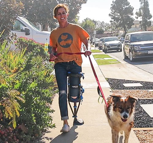 Lifestyle image of a person walking their dog while wearing the iWALK hands-free crutch iWALKFree